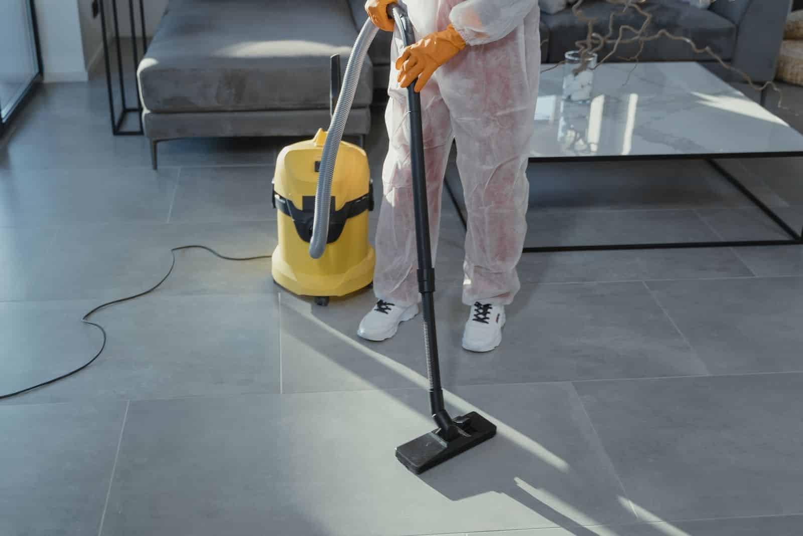 Professional residential cleaner vacuuming a modern living room